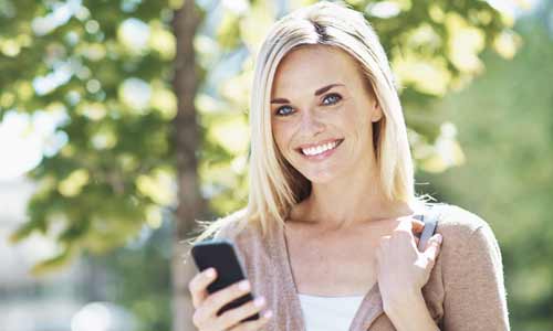 smile makeovers photo of woman smiling on phone